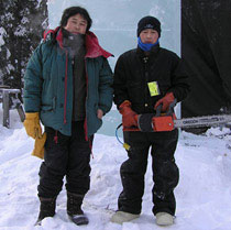 Qifeng An and Zhe An pose with chainsaw in front of an ice block, Ice Alaska’s World Ice Championships, 2007.